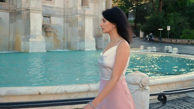 beautiful  woman walking in the city around the fountain wit model attitude