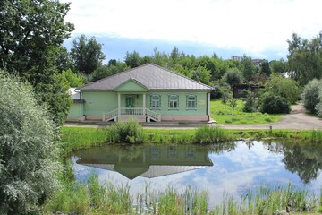 Obraz premium Beautiful wooden house by the pond. Russia.