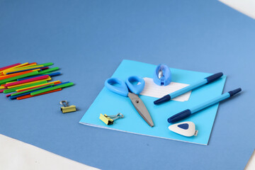 Counting sticks, notebooks, pencils, scissors on a blue background, side view-the concept of the beginning of the school year in schools