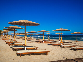 Empty deckchairs and parasols on empty beach