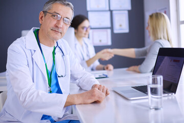 Doctor and patient discussing something while sitting at the table . Medicine and health care concept