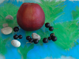 red Apple in a composition with currant and green leaves.the background glass is painted with watercolor.