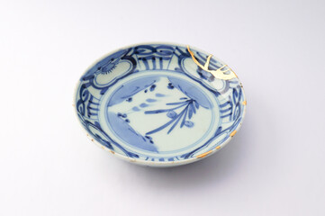 Japanese gold kintsugi plate. Antique handmade ceramic restored with the traditional Japanese kintsugi technique.