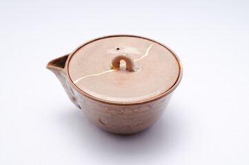 Fototapeta na wymiar Antique Japanese teapot kintsugi. Japanese tea ceremony pottery restored with gold.
