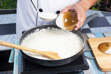 Chef spoon mushroom cream soup into a cup