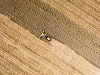 Aerial drone view. The harvester harvests wheat in the Ukrainian field.