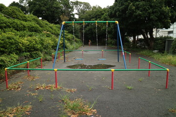 水たまりができた公園とブランコ