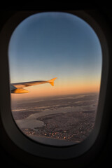A plane's wing seen from the window and New York City seen in the distance. New York seen from a plane's perspective.