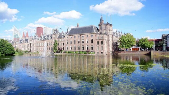Hofvijver reflection, the Dutch parliament building with Den Haag city scape in the background and the winds blowing the pond surface creating waves under a beautiful sunny spring, Netherlands