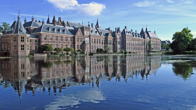 Hofvijver reflection, the Dutch parliament building with Den Haag city scape in the background and the winds blowing the pond surface creating waves under a beautiful sunny spring, Netherlands