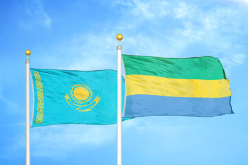 Kazakhstan and Gabon two flags on flagpoles and blue sky
