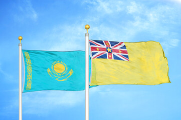 Kazakhstan and Niue two flags on flagpoles and blue sky