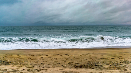 Waves on the beach on a cloudy day in Tauranga, New Zealand