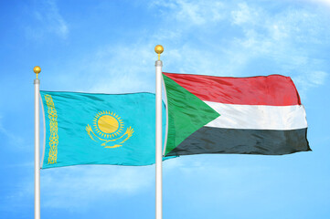 Kazakhstan and Sudan two flags on flagpoles and blue sky