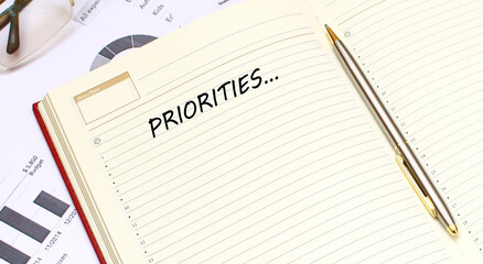 An open diary with text lies on an office desk with financial charts. Business concept.