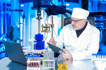 Doctor in medical laboratory. Doctor is working on vaccine. Lab technician is writing something. Medic in chemical laboratory. Concept - development of cures for epidemic. Creating a fever vaccine