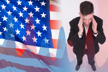 Depression due to crisis. Concept - stress due to financial problems. Man next to the USA flag. Graph shows the growth of negative factors. Guy in a suit holds his head. Depression in America.