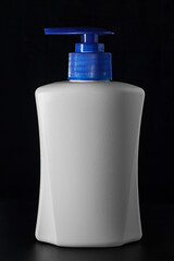 White soap bottle with a blue dispenser on a black background