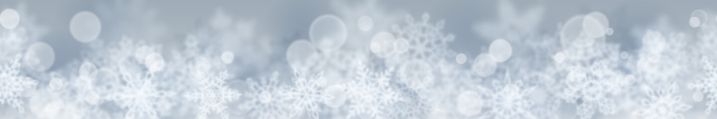 Christmas banner of blurry snowflakes on gray background