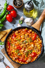 Traditional mexican food. Chili con carne from meat, beans and vegetables on dark stone table.