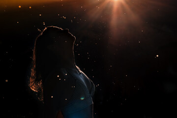Silhouette of woman at sunset with the sun in the background