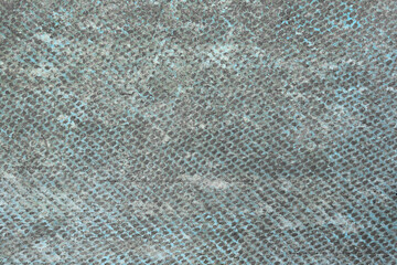 A dirty and worn textured concrete background with traces of blue paint with hollows and scratches.