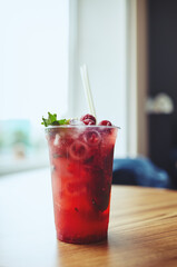Mojito cocktail or soda drink with lime,raspberry and mint on table in bar.Blurred image,selective focus