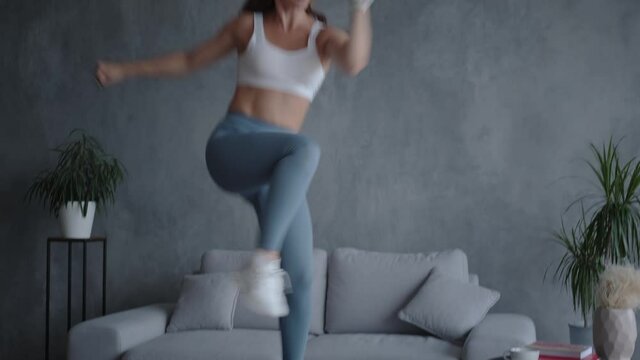 Energetic young woman in sportswear jumps on a mini trampoline enjoys