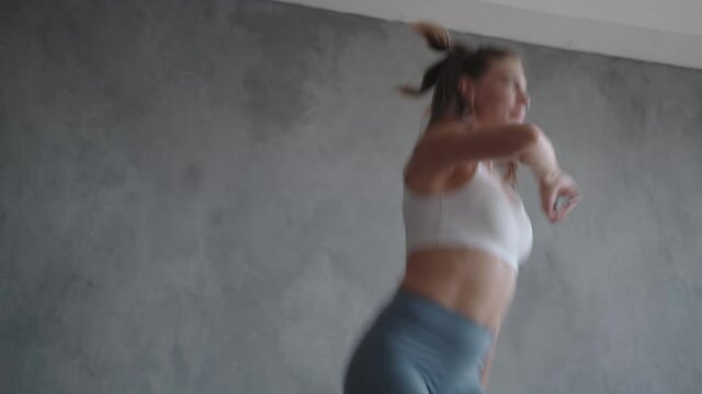 A sports woman jumps on a home mini trampoline, burning calories.