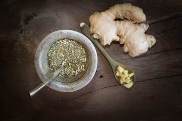 top view yerba mate and ginger for infusion on rustic wooden background
