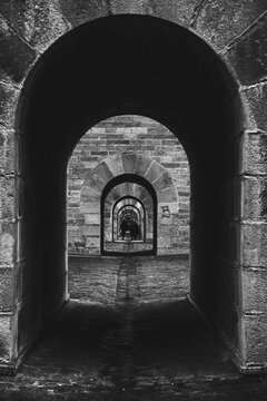 Urban scene. Silhouettes of tourist walking through viaduct of the historic town of Morlaix, in Brittany, France. Abstract life concept. Black white historic photo.