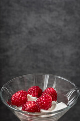 Food photo. Berry dessert. Sour cream with raspberries. Glamorous raspberry. Raspberry with cream in a glass goblet. Healthy eating. Summer foods and vitamins. Healthy breakfast and snack.