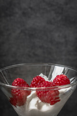 Food photo. Berry dessert. Sour cream with raspberries. Glamorous raspberry. Raspberry with cream in a glass goblet. Healthy eating. Summer foods and vitamins. Healthy breakfast and snack.