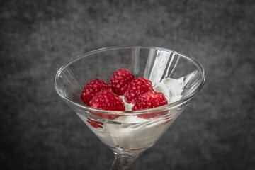 Food photo. Berry dessert. Sour cream with raspberries. Glamorous raspberry. Raspberry with cream in a glass goblet. Healthy eating. Summer foods and vitamins. Healthy breakfast and snack.