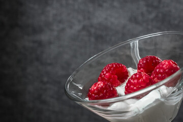 Food photo. Berry dessert. Sour cream with raspberries. Glamorous raspberry. Raspberry with cream in a glass goblet. Healthy eating. Summer foods and vitamins. Healthy breakfast and snack.