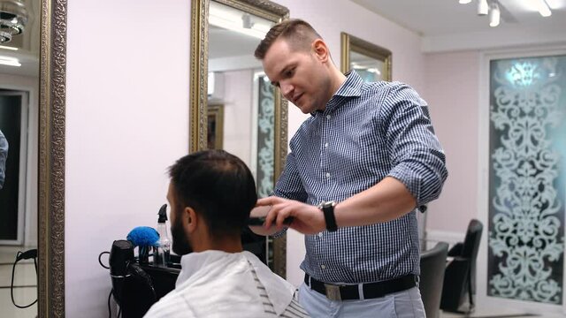 The professional barber discusses with the client how the cutter should be executed. Concept of reopening small and medium businesses