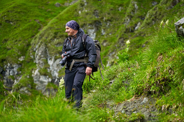 Hiker man with backpack on a mountain trail