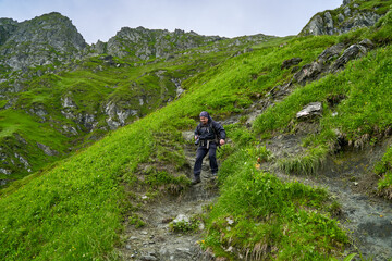 Fototapeta na wymiar Hiker man with backpack on a mountain trail