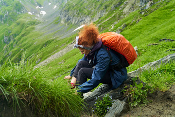 Woman hiker tying laces of her boots