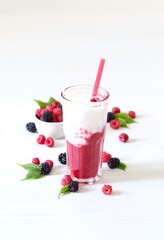Milk berry refreshing drink, cocktail with ice cream, fresh raspberries and blackberries in a glass on a white background