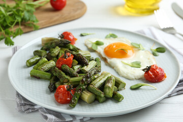 Oven baked asparagus served with fried egg on plate