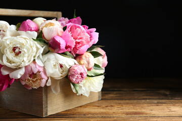 Bouquet of beautiful peonies on wooden table. Space for text