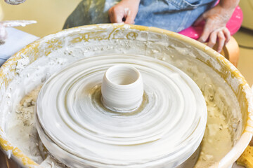 Children learning to make pottery as a hobby with their grandmother in a ceramics workshop