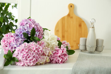 Obraz na płótnie Canvas Beautiful bouquet of hydrangea flowers on light countertop, closeup