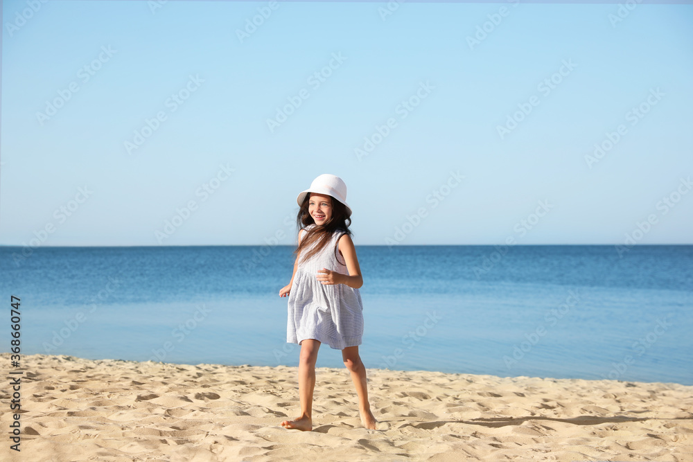 Sticker Cute little child running at sandy beach on sunny day