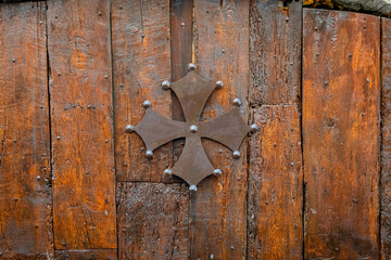 Croix en métal de l'Occitanie. Symbole de la région Occitanie-Pyrénées-Méditerranée, en France. Croix occitane sur fond de bois.