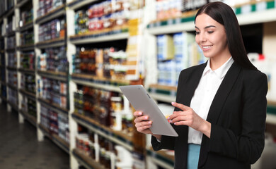 Wholesale and logistics concept. Manager using tablet computer in warehouse