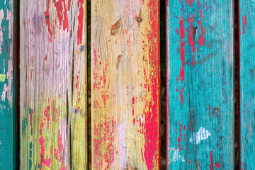Vintage colorful wooden boards with weathered cracked paint. Retro background with old wooden planks of different colors.