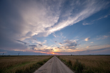 View down a rural road at sunset.