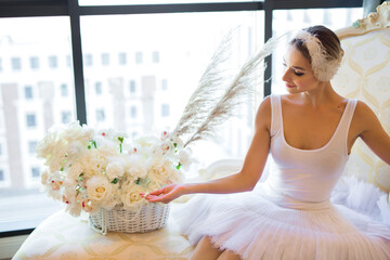 beautiful young woman in ballerina costume with a huge bouquet of white flowers